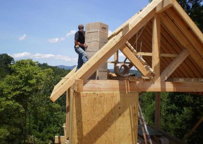 Isokern Fireplace Installation of brick. The house is only framed at this point. Nice trees and blue sky and mountains in the background.