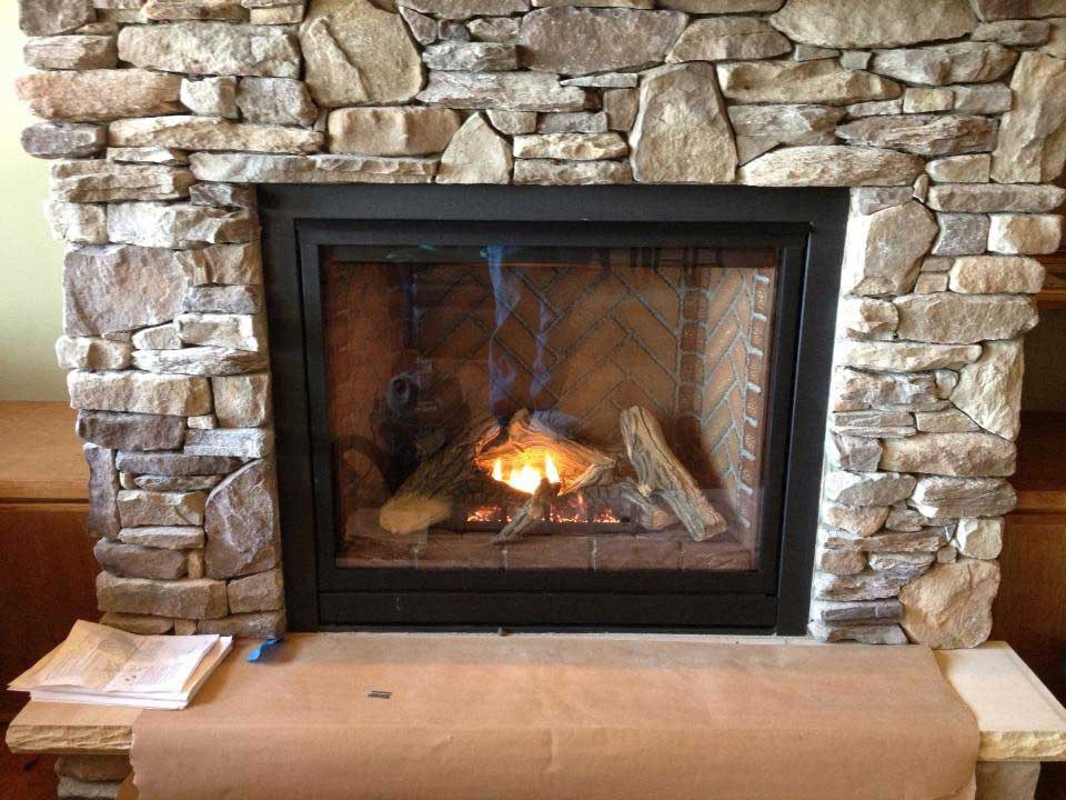 Beautiful fireplace with with stone surround and hearth.  Herringbone brick in the fire box. We do online video tours.