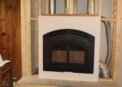 QuadraFire Wood Fireplace framed in with wood.