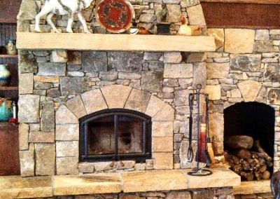 RSF Wood Fireplace in Mills River. Very elaborate stone surround and wood box. Accessories on the hearth.